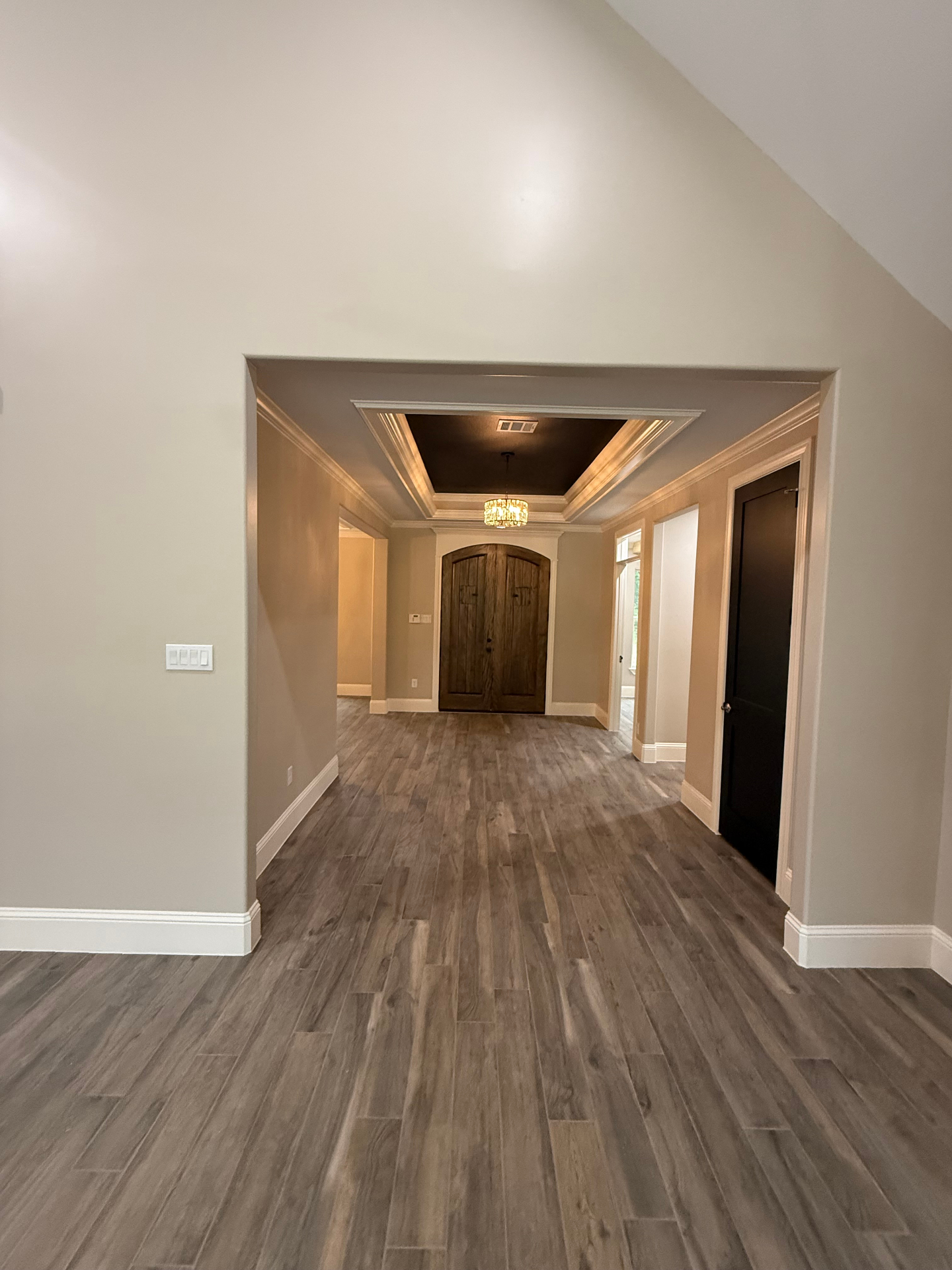 Foyer with custom doors, chandelier, and finished flooring
